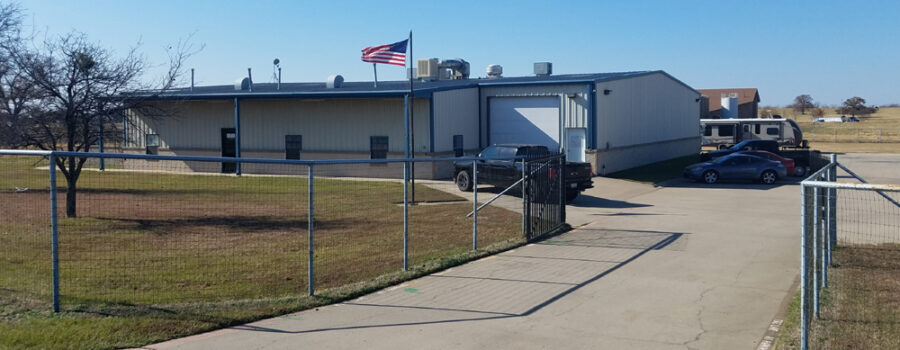 A fence is shown outside of an industrial building.