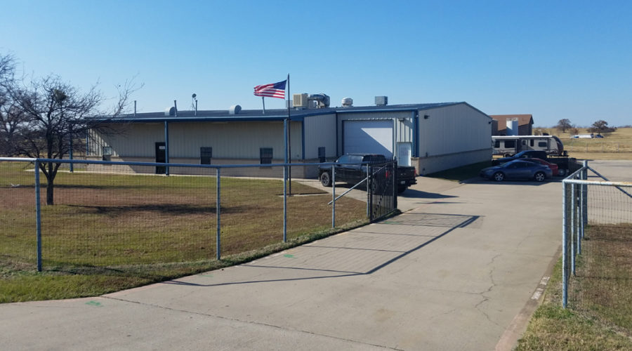 A fence is shown outside of an industrial building.