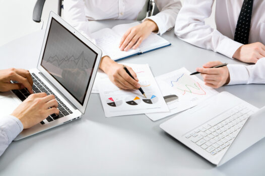 A group of people sitting around a table with papers.