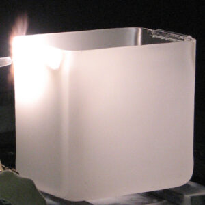 A white square vase sitting on top of a table.